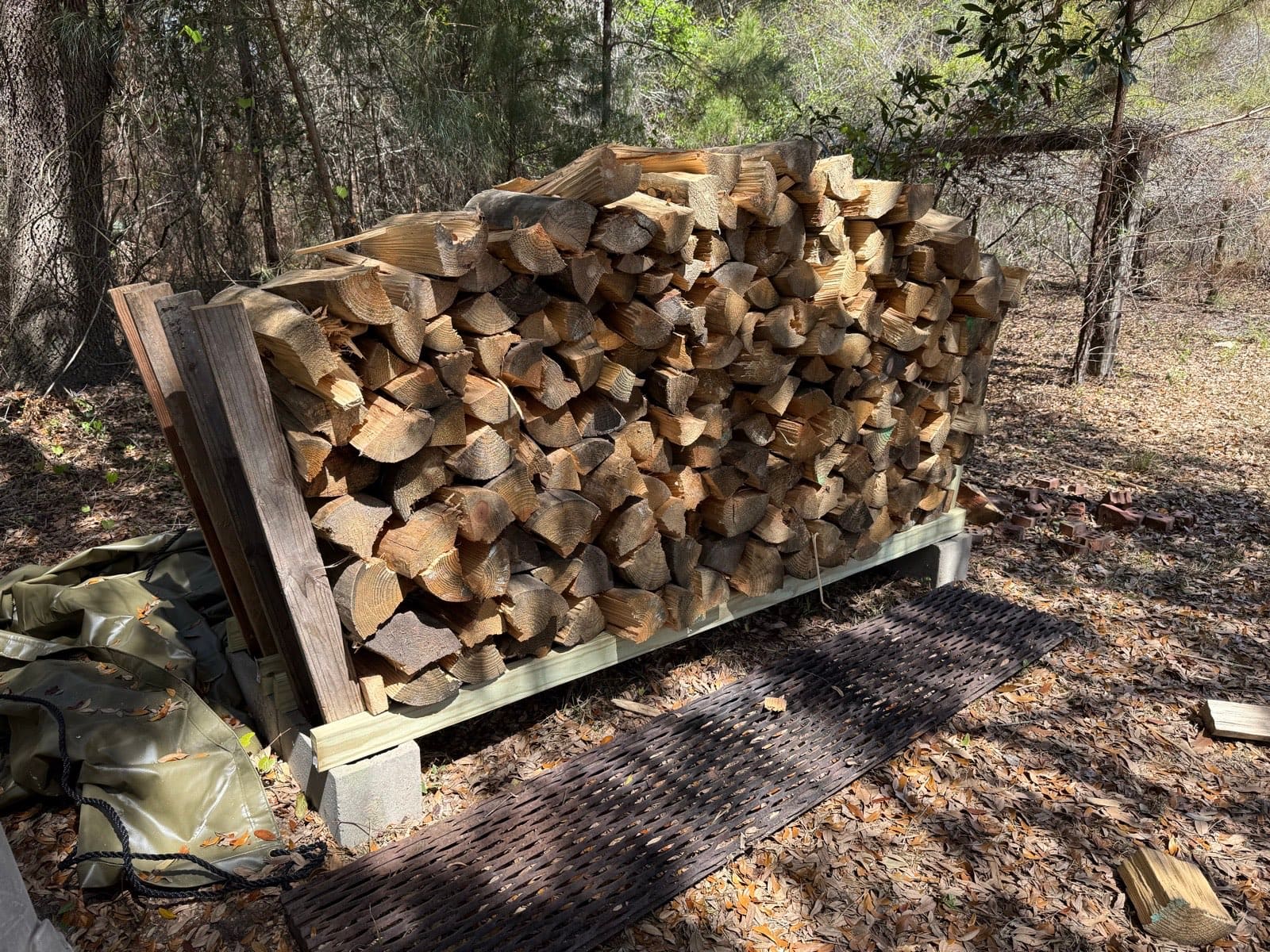 A stacked cord of split, kiln-dried pine airing on one of the racks the boys build.