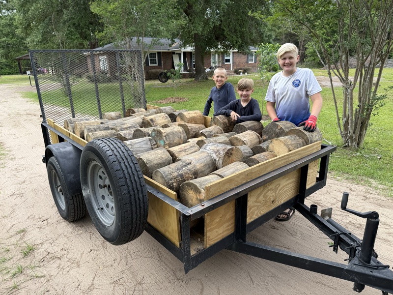 The three brothers with a trailer of whole rounds, ready for the route.