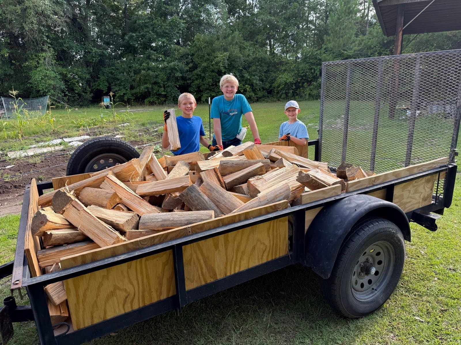 The three brothers with a trailer of split wood, ready for the route.